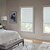 Lifestyle bedroom scene with Contemporary decor featuring the Motorized Blackout Roller Shades in the Paramount Ice color.